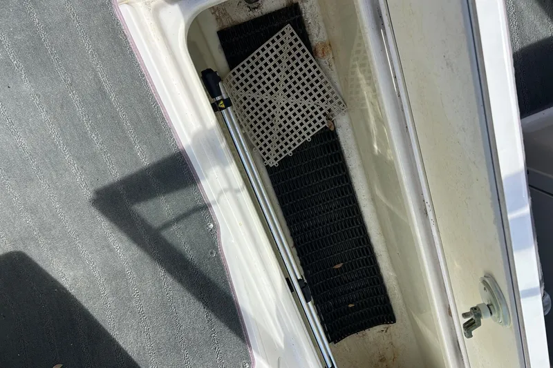 Slide: The Image of Storage compartment of a 2022 Yamaha SX190 boat with mats and a hydraulic rod. - 18