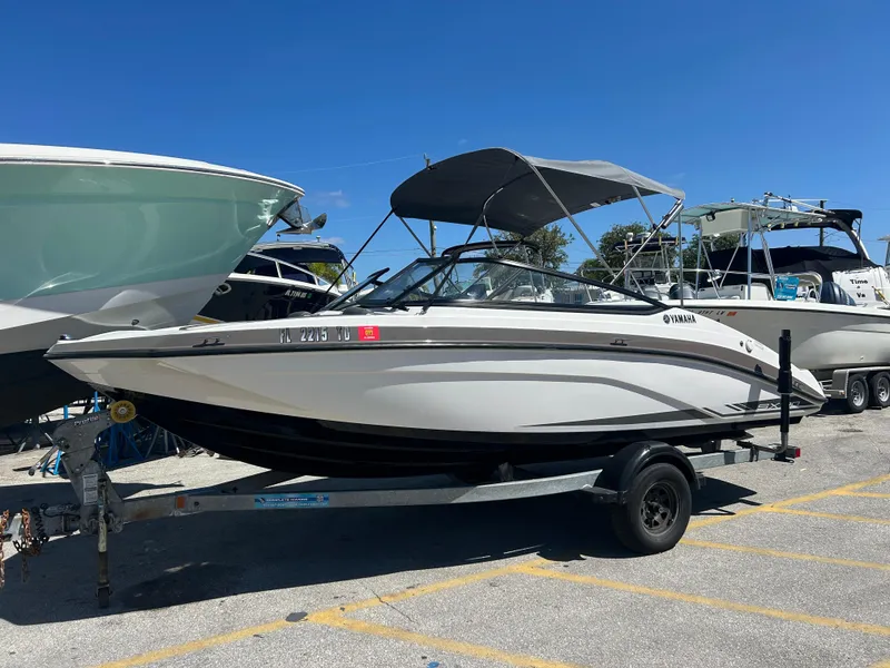 Slide: The Image of 2022 Yamaha SX190 boat on trailer, parked in marina under clear blue sky. - 20