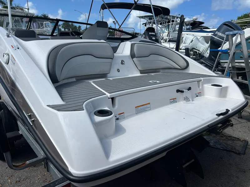 Slide: The Image of 2022 Yamaha Boats SX190, rear view, showcasing seating and swim platform in a marina setting. - 3