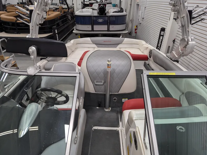 Slide: The Image of 2012 MasterCraft X-14 boat interior with red and gray seating, steering wheel, and windshield. - 16
