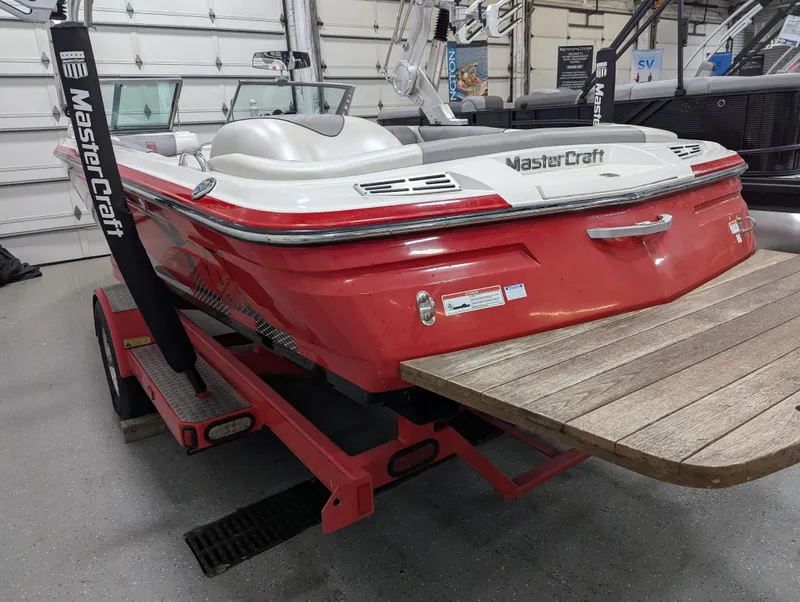 Slide: The Image of 2012 MasterCraft X-14 boat in a garage, red and white design, on a trailer. - 28