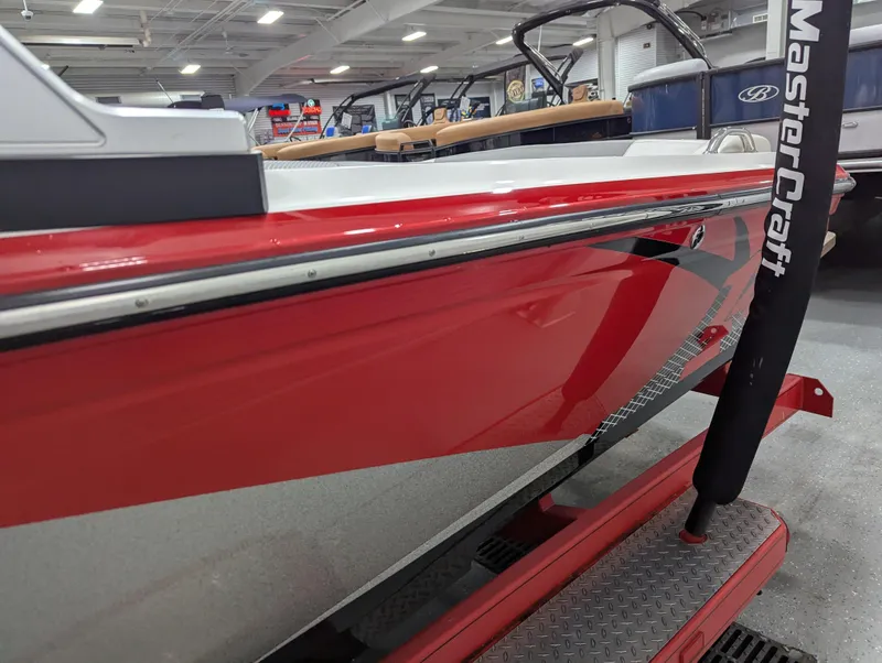 Slide: The Image of 2012 MasterCraft X-14 boat with red and white exterior in showroom. - 3
