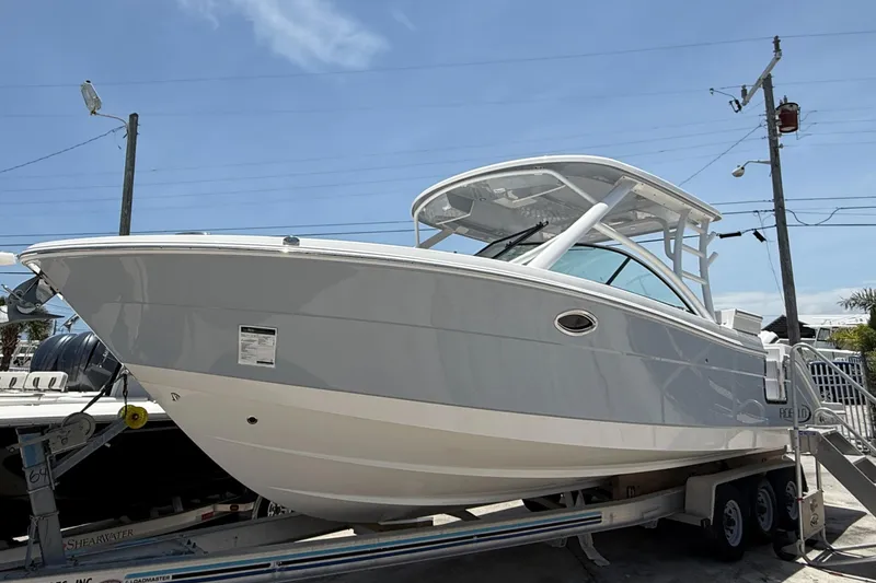 The Image of 2024 Robalo R317 Dual Console boat on trailer, side view under clear sky. - 0