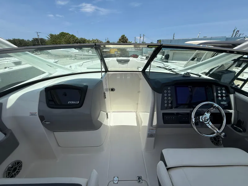 Slide: The Image of 2024 Robalo R317 Dual Console boat cockpit with modern controls and steering wheel. - 13