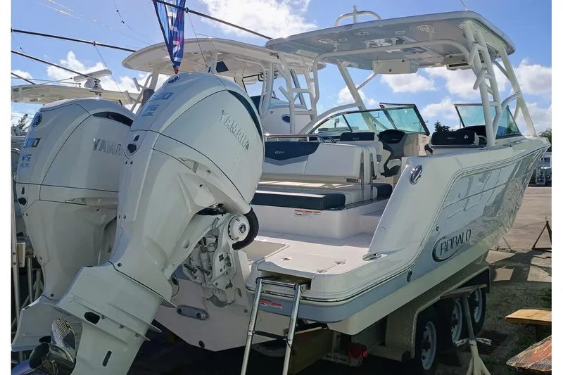 Slide: The Image of 2024 Robalo R317 Dual Console boat with twin Yamaha outboard engines, docked on a trailer. - 3