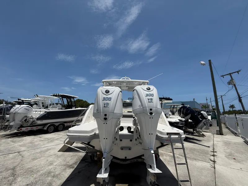 Slide: The Image of 2024 Robalo R317 Dual Console boat with twin 300 HP engines, docked under clear skies. - 5