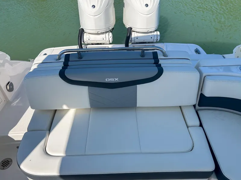 Slide: The Image of 2024 Chaparral 280 OSX boat with cushioned seating and dual outboard motors. - 10