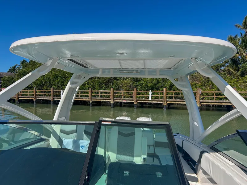 Slide: The Image of 2024 Chaparral 280 OSX boat with sleek design, docked by a wooden fence. - 8