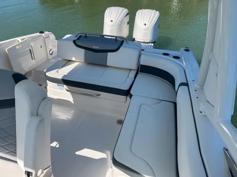 Slide: The Image of 2024 Chaparral 280 OSX boat interior with seating and dual engines on water. - 9