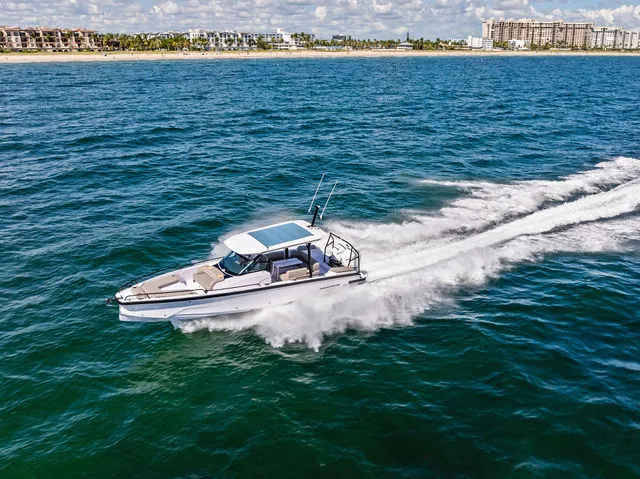 Slide: The Image of 2026 Axopar 29 Sun-Top boat cruising on open water with American flag. - 26