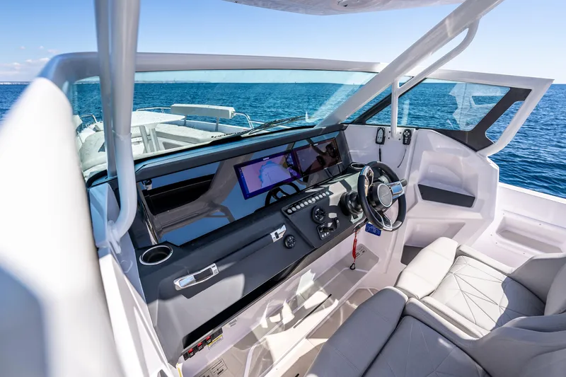 Slide: The Image of 2025 Axopar 29 Sun Top boat cruising on a serene lake with forested hills. - 3