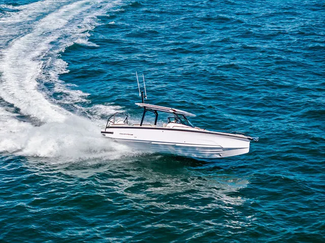 Slide: The Image of 2026 Axopar 29 Sun-Top boat with white seating, cruising on a serene lake. - 32