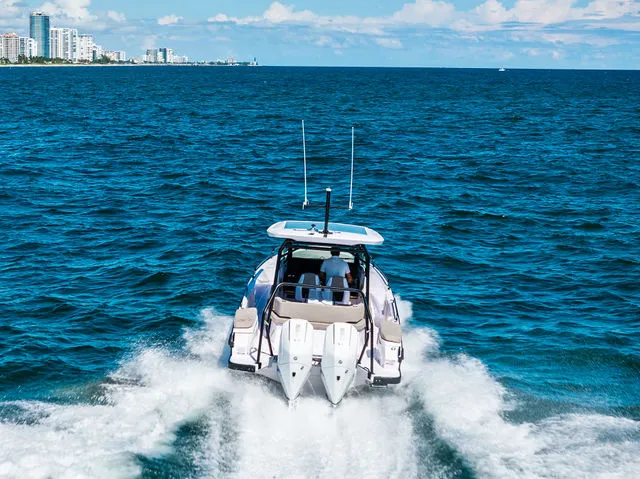 Slide: The Image of 2026 Axopar 29 Sun-Top boat deck with cushioned seating on open water. - 33