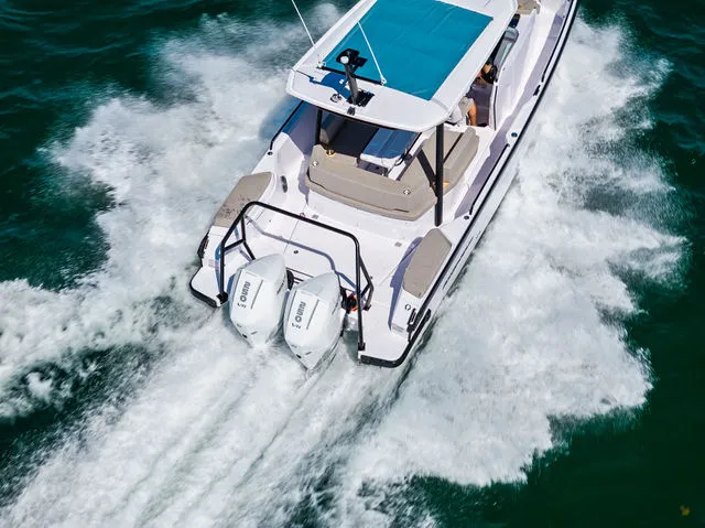 Slide: The Image of 2026 Axopar 29 Sun-Top boat on calm water, showcasing sleek design and spacious seating. - 36