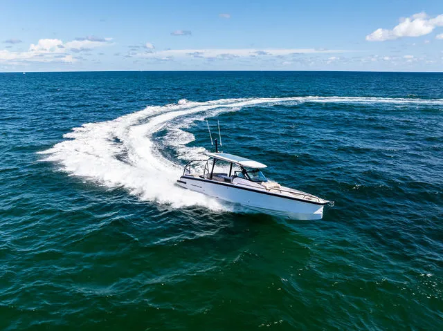 Slide: The Image of 2026 Axopar 29 Sun-Top boat on water, featuring sleek design and spacious seating. - 38