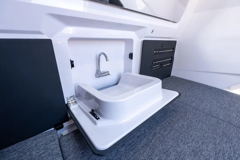 Slide: The Image of Interior view of 2026 Axopar 29 Sun-Top boat featuring a compact sink and faucet. - 41