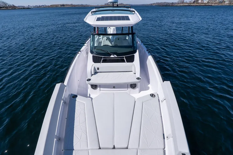 Slide: The Image of 2026 Axopar 29 Sun-Top boat on calm blue water, showcasing sleek design and spacious deck. - 47