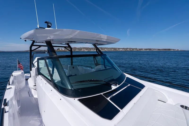 Slide: The Image of 2026 Axopar 29 Sun-Top boat on calm water, clear sky background. - 49