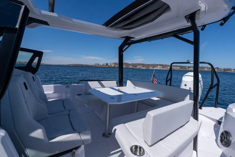 Slide: The Image of 2026 Axopar 29 Sun-Top boat interior with seating and table on open water. - 50