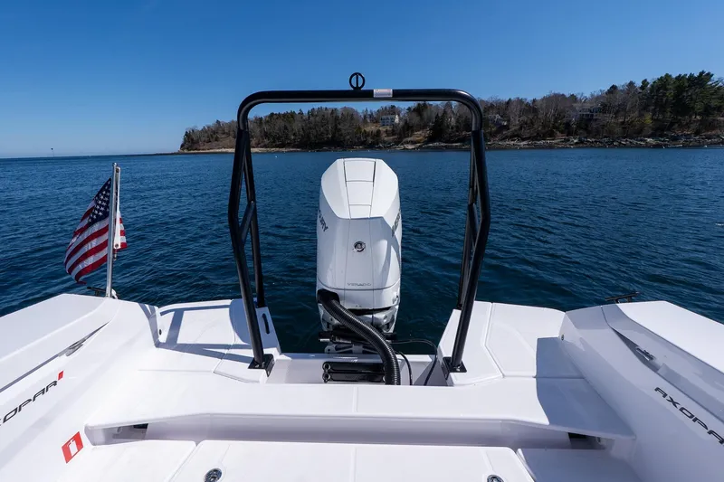 Slide: The Image of 2026 Axopar 29 Sun-Top boat with outboard motor on calm water, American flag visible. - 53