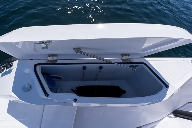 Slide: The Image of Open storage compartment on 2026 Axopar 29 Sun-Top boat, with ocean background. - 55