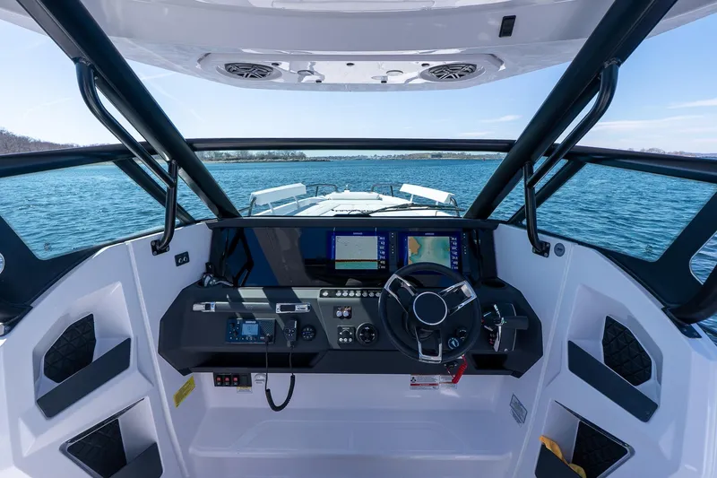 Slide: The Image of 2026 Axopar 29 Sun-Top boat cockpit with modern navigation system on open water. - 60