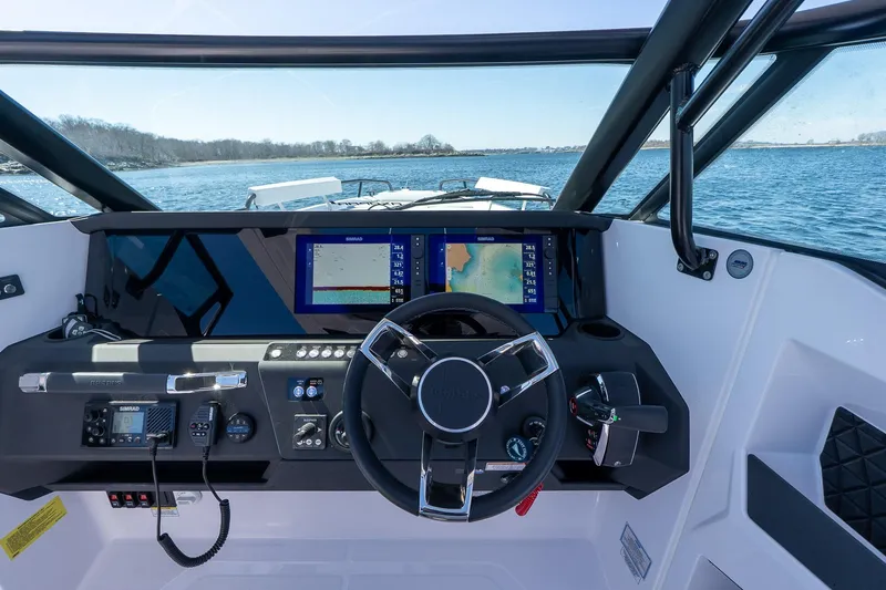 Slide: The Image of Cockpit view of 2026 Axopar 29 Sun-Top boat with navigation screens and steering wheel. - 61