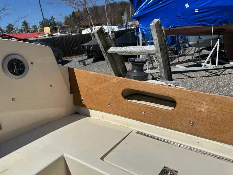 Slide: The Image of 1968 Allied Greenwich 24 sailboat cockpit with wooden trim and gauge, docked outdoors. - 11