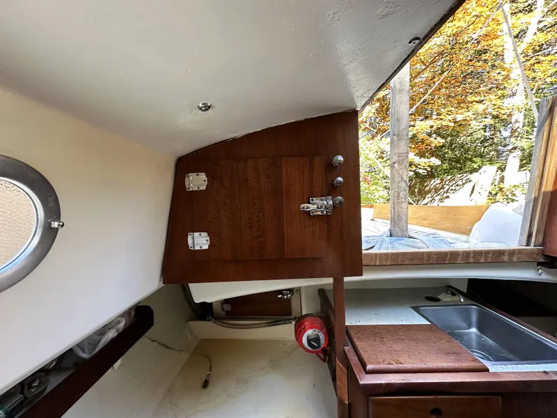 Slide: The Image of Interior of 1968 Allied Greenwich 24 sailboat, featuring wooden cabinetry and a small sink. - 14