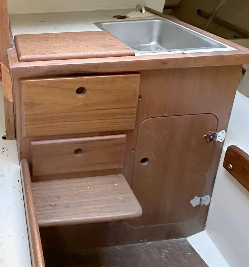 Slide: The Image of 1968 Allied Greenwich 24 boat interior with wooden cabinetry and stainless steel sink. - 15