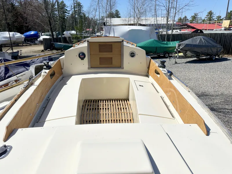 Slide: The Image of 1968 Allied Greenwich 24 sailboat deck with wooden accents, docked outdoors. - 7