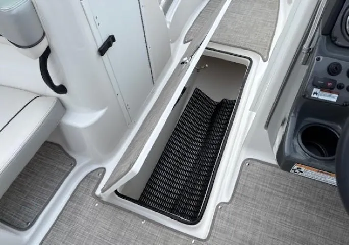 Slide: The Image of 2012 Yamaha AR210 boat interior storage compartment with open hatch and textured flooring. - 15