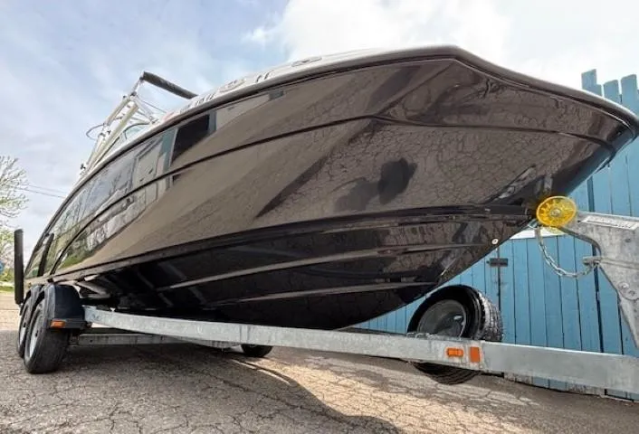 Slide: The Image of 2012 Yamaha Boats AR210 on trailer, sleek black hull, parked outdoors. - 3