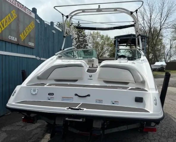 Slide: The Image of 2012 Yamaha AR210 boat, rear view, parked outdoors near a blue fence. - 5