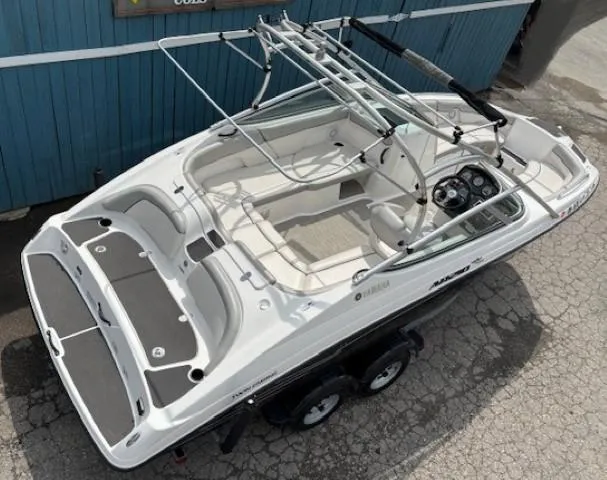 Slide: The Image of 2012 Yamaha AR210 boat, white exterior, spacious seating, dual axle trailer, parked on concrete. - 7
