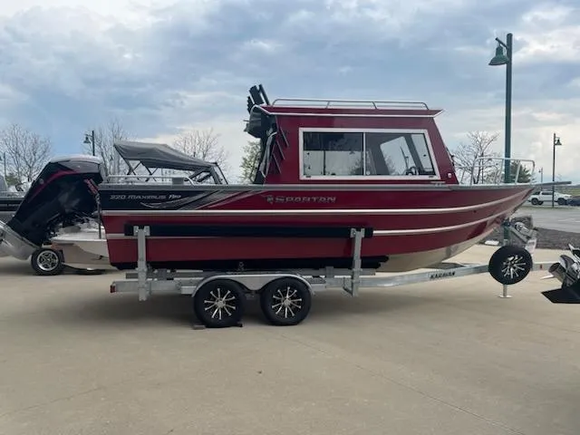 Slide: The Image of 2024 Spartan 220 Maximus boat on trailer, red exterior, parked outdoors. - 3