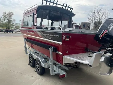 Slide: The Image of 2024 Spartan 220 Maximus boat on trailer, red exterior, parked outdoors. - 4