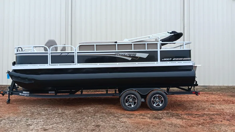 Slide: The Image of 2022 Ranger 200F pontoon boat on trailer, black and white design, parked outdoors. - 0
