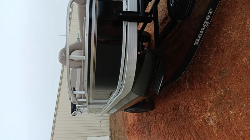 Slide: The Image of 2022 Ranger 200F boat on trailer, parked on gravel near a building. - 1