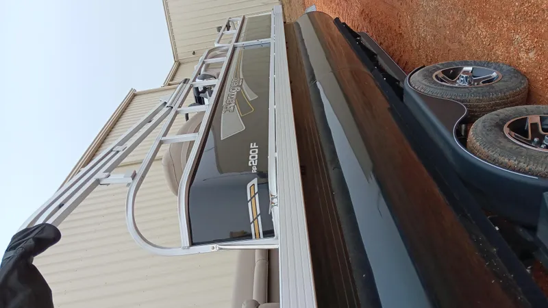 Slide: The Image of 2022 Ranger 200F boat on trailer, side view, parked on gravel. - 17