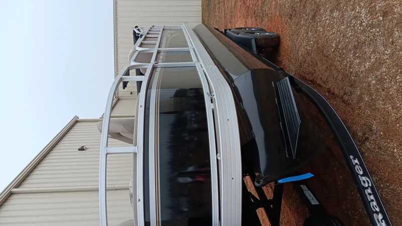 Slide: The Image of 2022 Ranger 200F boat on trailer, parked outdoors near a building. - 2