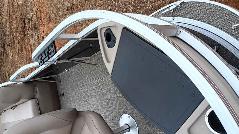 Slide: The Image of 2022 Ranger 200F boat interior with beige seating and carpeted flooring. - 23