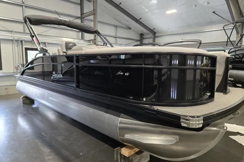 Slide: The Image of 2025 Barletta A22UC pontoon boat in a showroom, featuring sleek black design. - 6