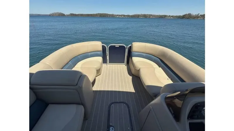 Slide: The Image of 2019 Manitou 23 Aurora LE Bar pontoon boat interior with spacious seating on a calm lake. - 13