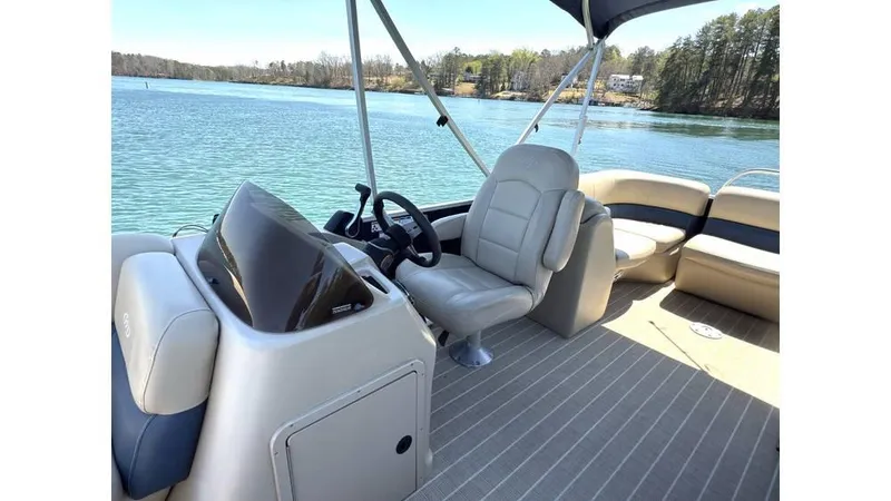 Slide: The Image of 2019 Manitou 23 Aurora LE Bar pontoon boat interior on a serene lake. - 15
