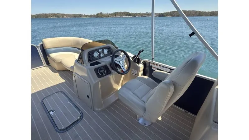 Slide: The Image of 2019 Manitou 23 Aurora LE Bar pontoon boat interior with steering console and seating. - 17