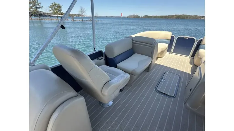 Slide: The Image of 2019 Manitou 23 Aurora LE Bar pontoon boat interior with comfortable seating on a lake. - 8