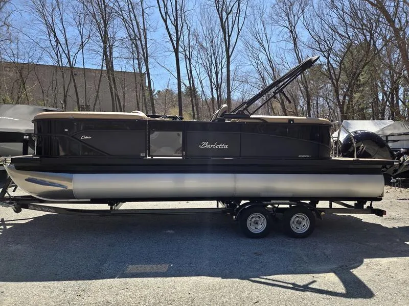 Slide: The Image of 2025 Barletta C22QC pontoon boat on trailer, parked outdoors. - 6