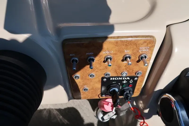 Slide: The Image of Control panel of a 2012 Berkshire G210CL boat with switches and Honda ignition. - 25
