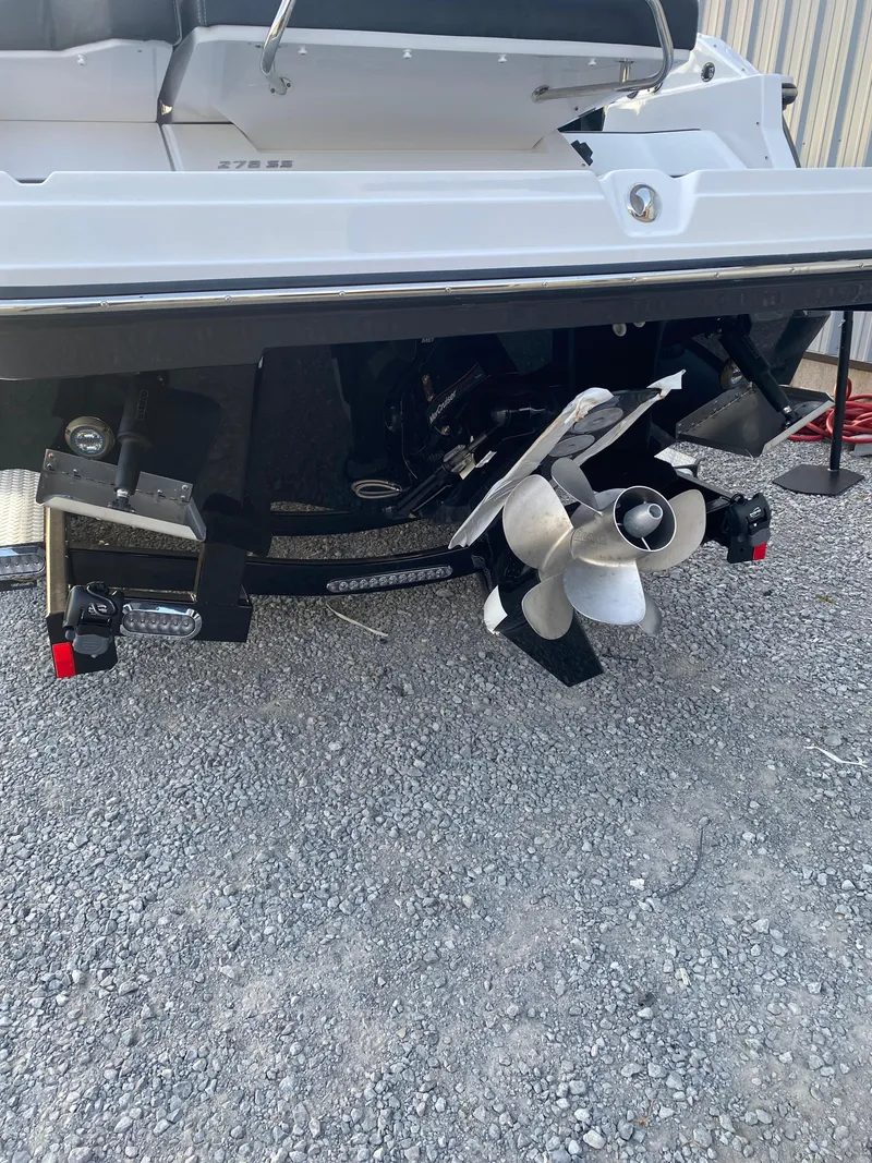 Slide: The Image of 2025 Monterey 278 Super Sport boat stern with dual propellers on gravel surface. - 9